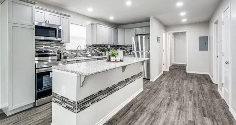 Renovated kitchen with white cabinets, island and stainless appliances